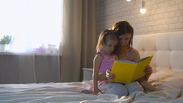 Mom With Daughter At Home On The Bed