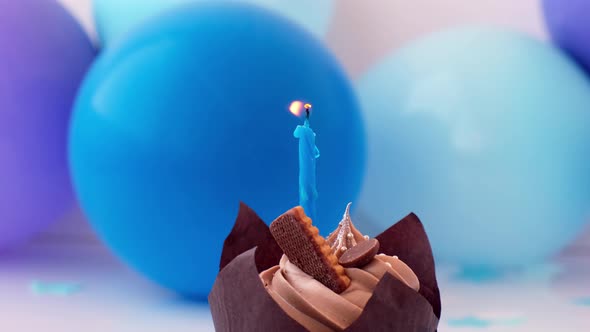 Sweet Tasty Chocolate Cupcake with Candle Burning on Blue Festive Background