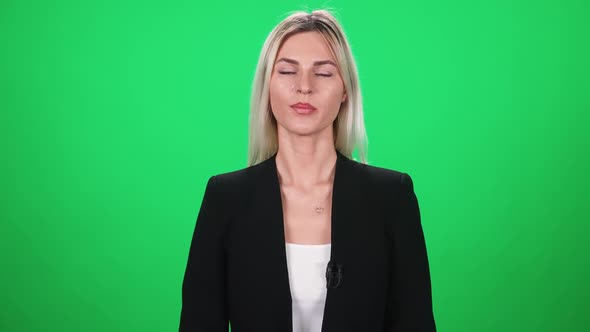 Female Reporter in Suit Looks Into the Camera and Speaks Female on a Green Background Template for