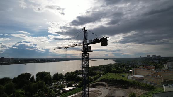 Aerial View of a Crane of a Construction Site Near the River Above the City at Sunset 5