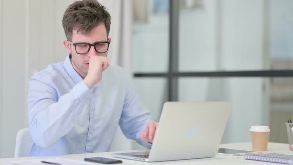 Young Man with Laptop Having Coughing
