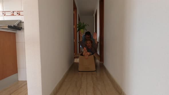 Couple of adult having fun together in a new house playing with a small box