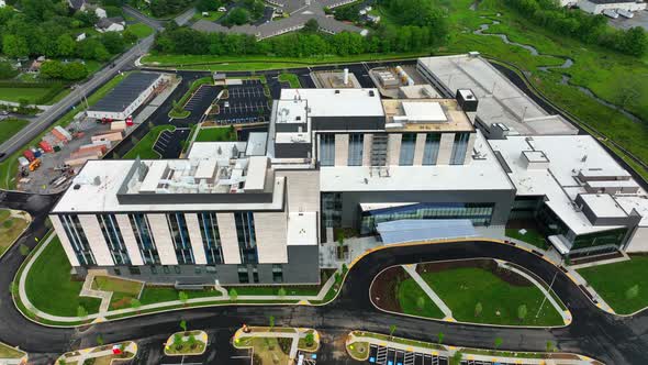 Modern American hospital building, new construction aerial reveal. State of the art medical facility