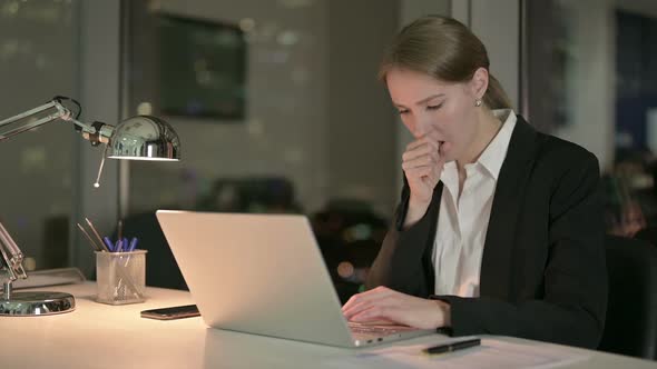 Sick Businesswoman Coughing While Working in Office at Night