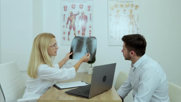 Female Doctor Checking Xray Lungs Consulting a Patient Positive for Coronavirus Supporting