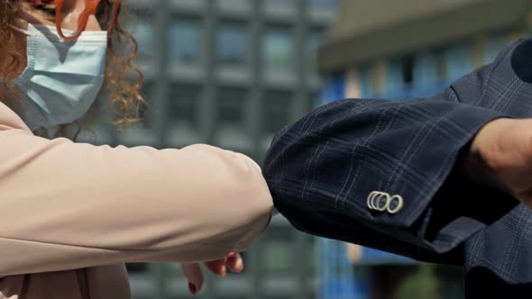 Man and Woman Bumping Elbows to Say Hello Outdoors