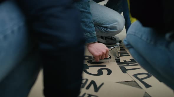 Caucasian man preparing cardboard banners for manifest against Ukrainian war. Shot with RED helium c