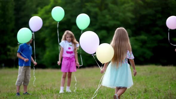 Group of Happy Children Playfully Running with Multicolored Balloons