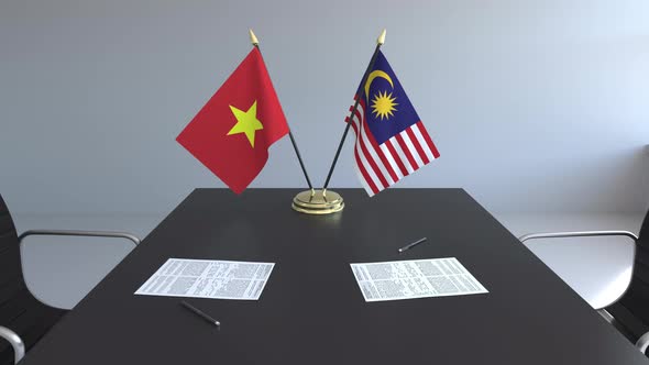 Flags of Vietnam and Malaysia on the Table