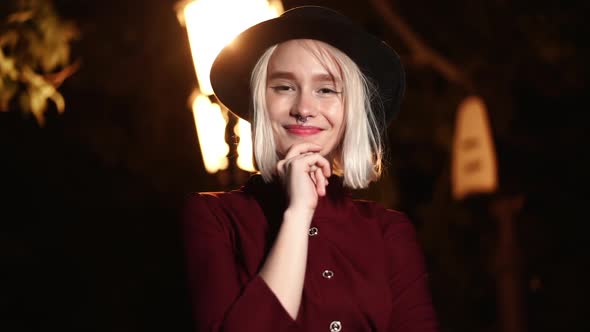 Portrait of Millennial Hipster Woman with Blond Hairstyle Under the Lantern of City Street at Night