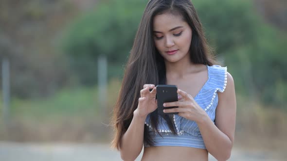 Young Happy Asian Tourist Woman Using Phone