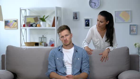 Phlegmatic Man Sitting on Sofa Listening Nervous Wife Shouting, Aggression