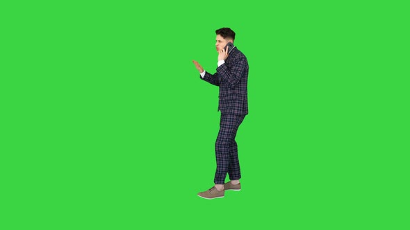 Young Angry Emotional Man in Formal Suit Talking on the Phone and Dancing After on a Green Screen