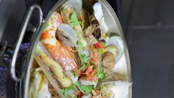 Cataplana with Fresh Seafood and Vegetables Is Cooked on a Fire