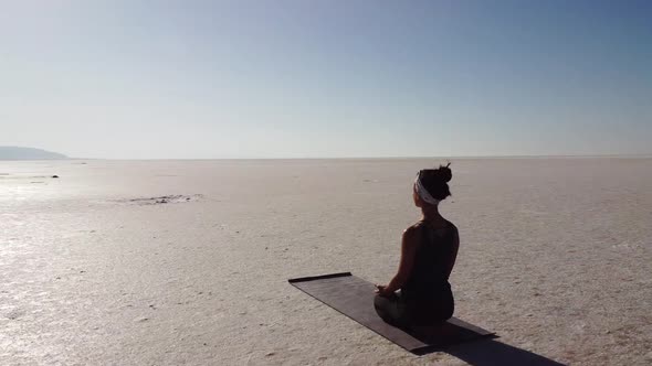 Woman teacher doing meditation pose on the Lake Tuz, Salar in Turkey. Good vibes and energy.
