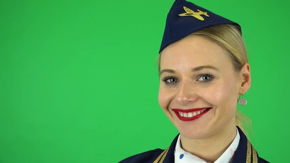 A Young Beautiful Stewardess Smiles at the Camera - Face Closeup - Green Screen Studio