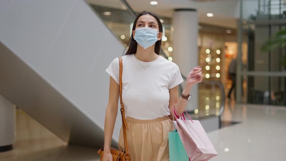 Young Woman in Medical Face Mask Walking in Shopping Center