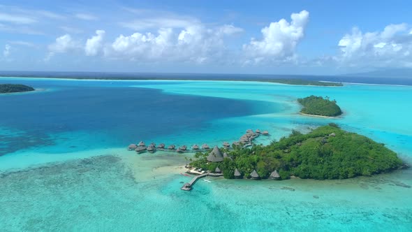 Aerial drone view of a luxury resort and overwater bungalows in Bora Bora tropical island