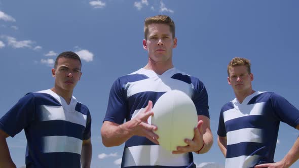 Rugby players standing with ball