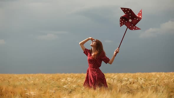 Video of young redhead woman with pinwheel toy on wheat field