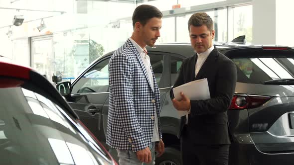 Serious Men Sign a Car Purchase Contract