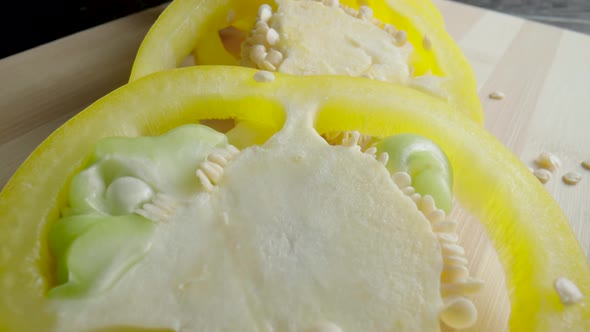 Sliced Rings of Fresh Raw Yellow Bell Peppers on Wooden Board