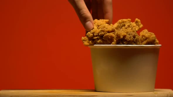 Woman Slowly Taking Crispy Chicken From Plastic Basket, Unhealthy Snack, Closeup