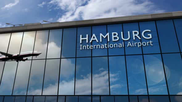 Airplane landing at Hamburg Germany airport mirrored in terminal