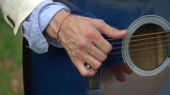 Close-up detail of a man playing guitar hands