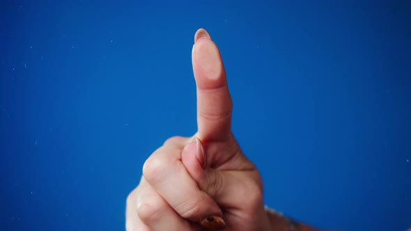 Female Human Hand Making Fingerprint on Blue Background