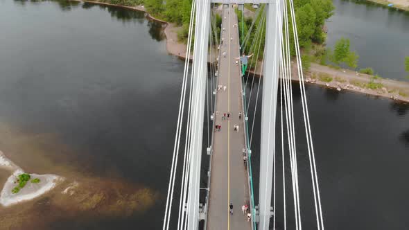 A Man Walks on a Rope Stretched Between the Supports of the Bridge at High Altitude.