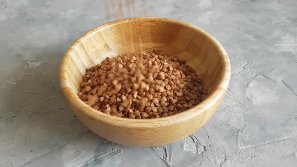 Raw dry buckwheat grain in a bowl close up