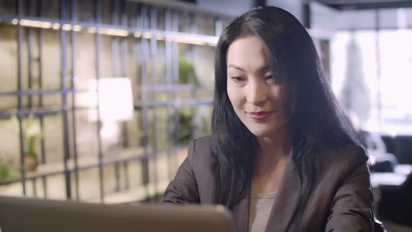 Smiling Businesswoman Working on Laptop