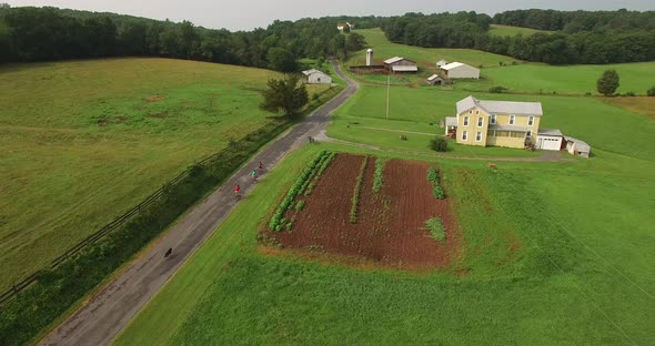 Aerial views of family bicycling along pastoral country roads.