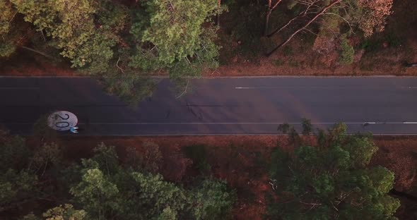 The Drone Takes Off Over a Forest Road with a Bicycle Path with a Speed Limit of 20 Km