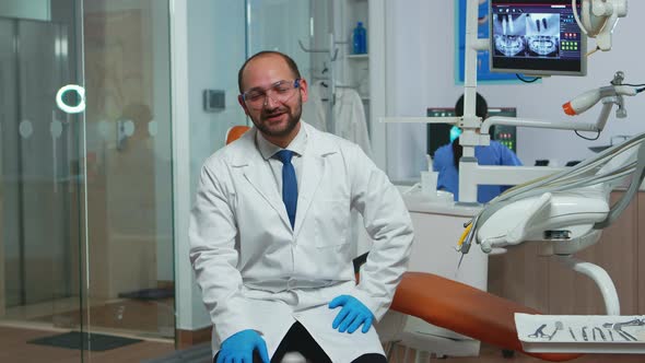 Dentist Doctor Looking at Camera Talking with Patients