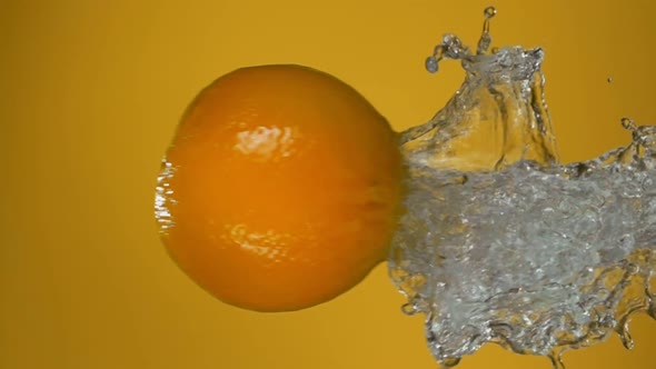 Ripe Juicy Orange is Bouncing Horizontally From Water with Beautiful Splashes