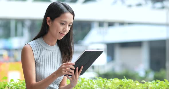 Asian Woman looking at tablet computer in Hong Kong city