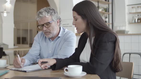 Business Partners Sitting at Table with Cups