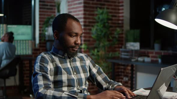 Sales Consultant Analyzing Forex Stock Trade Numbers on Laptop