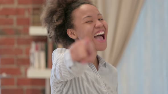 Portrait of African American Woman Pointing Towards Camera