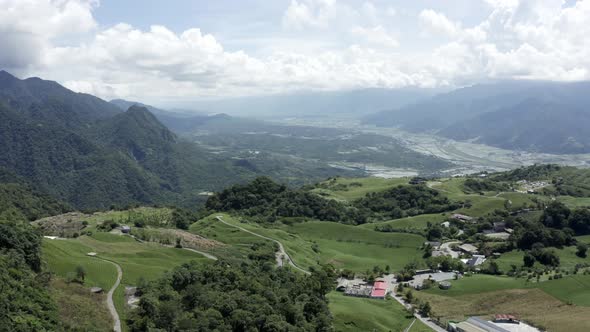 Aerial video from flying a drone over a small village in the high mountain forest. Cloud moving and