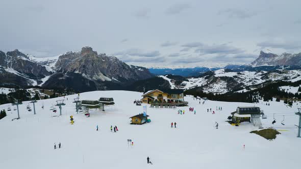 Aerial, Ski Facilities On Top Of Snowy Dolomites And Skiers In The Middle