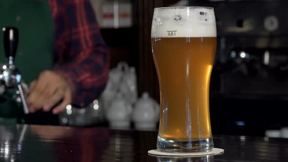 Bartender Taking Away Glass of Beer From Bar Counter