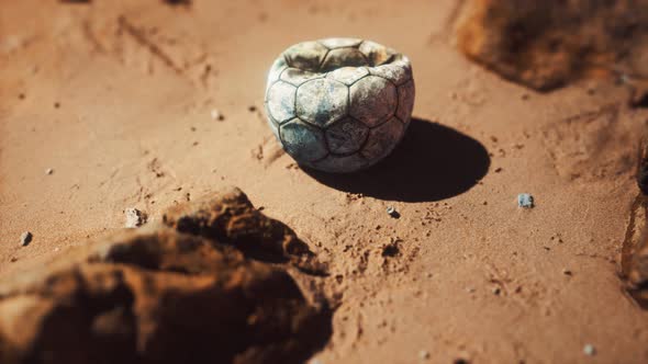 Old Football Ball on the Sand Beach