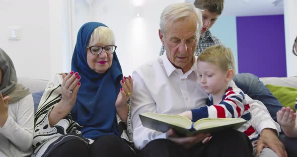 Muslim Family Generations Grandparents Reading Quran with Grandchildren at Home