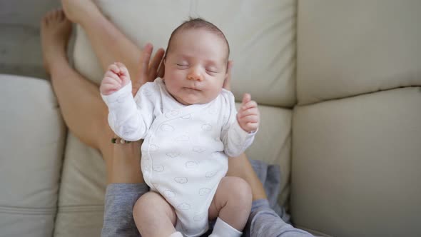 Happy Young Mother Holding Her Newborn Baby in Her Arms