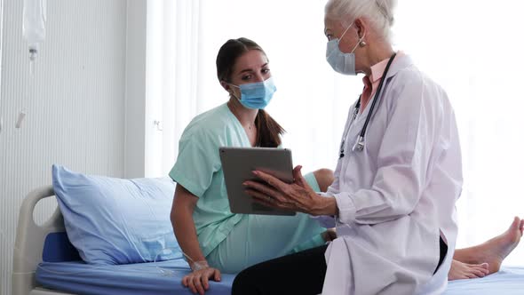 Senior Female doctor explaining woman patient's results from sick symptoms and insurance condition