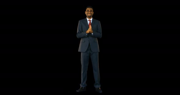 Businessman standing and smiling against black background