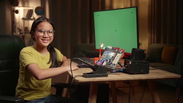 Asian Girl Is Working With Desktop Computer And Mainboard In Home, Mock Up Green Screen Display